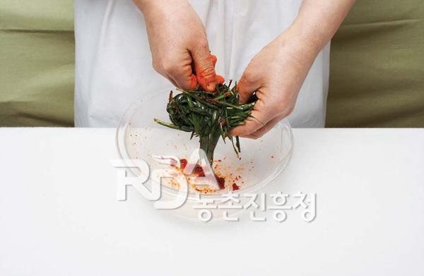 버무린 부추를 돌돌 만다.